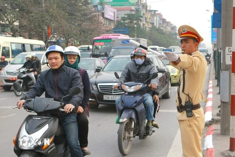 Chiến sỹ cảnh sát giao thông Hà Nội làm nhiệm vụ phân luồng giao thông trong giờ cao điểm trên trục đường Giải phóng. (Ảnh: Doãn Tấn/TTXVN)