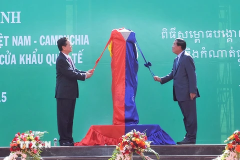 Thủ tướng Nguyễn Tấn Dũng và Thủ tướng Campuchia Hun Sen thực hiện nghi thức mở băng khánh thành Cột mốc 30 và đường nối hai trạm kiểm soát. (Ảnh: Trọng Đức/TTXVN)