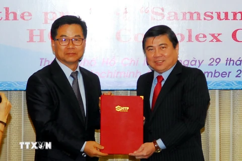 Chủ tịch Ủy ban Nhân dân Thành phố Hồ Chí Minh Nguyễn Thành Phong trao giấy chứng nhận cho dự án “Công ty TNHH điện tử SamSung HCMC CE Complex.” (Ảnh: Mạnh Linh/TTXVN)