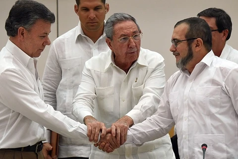 Tổng thống Colombia Juan Manuel Santos (trái) bắt tay với lãnh đạo Farc, Timochenko (phải) dưới sự bảo trợ của Chủ tịch Cuba Raul Castro, tháng 9/2015. (Nguồn: AFP)