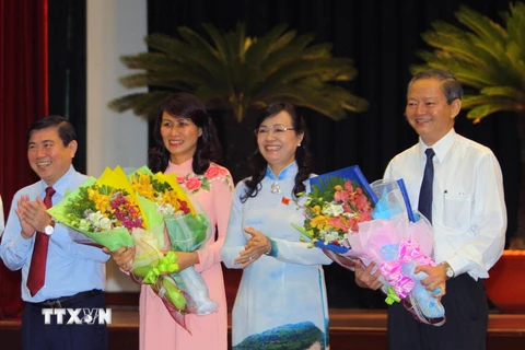Ông Lê Văn Khoa và bà Nguyễn Thị Thu, tân Phó chủ tịch Ủy ban Nhân dân Thành phố Hồ Chí Minh nhận hoa chúc mừng của lãnh đạo thành phố. (Ảnh: Hoàng Hải/TTXVN)