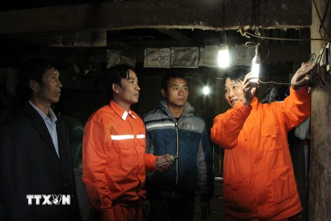 Công nhân điện lực Lai Châu lắp mới bóng đèn cho các hộ dân vùng cao Lai Châu. (Ảnh: Nguyễn Duy/TTXVN)