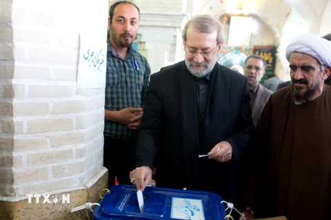 Chủ tịch Quốc hội Iran Ali Larijani (giữa) bỏ phiếu tại điểm bầu cử ở thành phố Qom, cách Tehran 130km về phía nam ngày 26/2. (Nguồn: AFP/TTXVN)