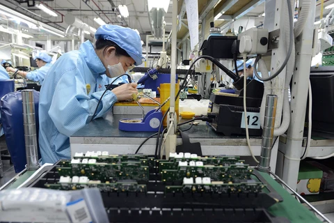 Công nhân làm việc trong một nhà máy sản xuất linh kiện điện tử ở Singapore. (Nguồn: businesstimes.com.sg)