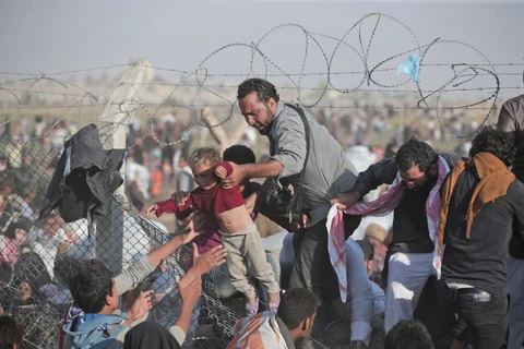 Người tị nạn Syria vượt biên giới vào Thổ Nhĩ Kỳ. (Nguồn: AP)