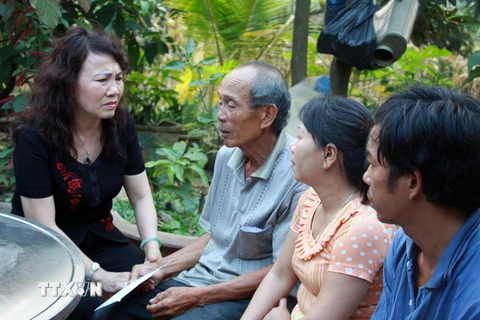 Thứ trưởng Bộ Giáo dục và Đào tạo Nguyễn Thị Nghĩa thăm hỏi, chia sẻ, động viên và trao số tiền hỗ trợ cho gia đình 9 học sinh bị chết đuối. (Ảnh: Vĩnh Trọng/TTXVN)