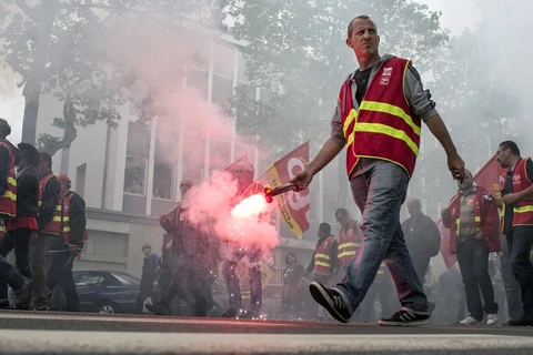 Một người biểu tình cầm pháo sáng trong cuộc tuần hành ở Lyon. (Nguồn: AP)