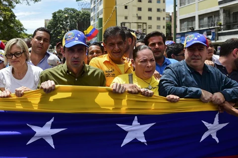 Phe đối lập Venezuela biểu tình trước trụ sở Cơ quan bầu cử quốc gia (CNE) đòi tiến hành trưng cầu ý dân về bãi nhiệm Tổng thống. (Nguồn: AFP)