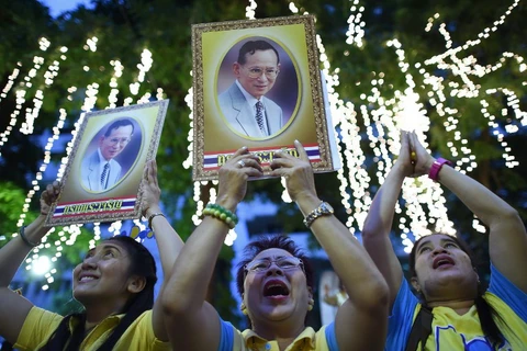 Người dân Thái Lan cầm ảnh chân dung Nhà Vua Thái Lan Bhumibol Adulyadej trong dịp kỷ niệm 88 năm ngày sinh Nhà Vua, tháng 12/2015. (Nguồn: AFP)