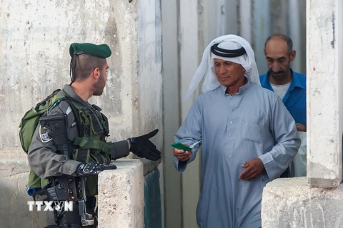 Binh sỹ Israel kiểm tra giấy tờ của một người dân Palestine tại cửa khẩu ở Bethlehem, Bờ Tây ngày 10/6. (Nguồn: THX/TTXVN)