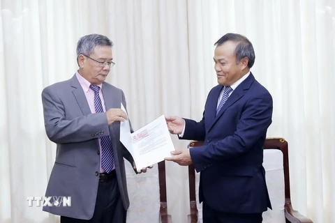 Thứ trưởng Bộ Ngoại giao Vũ Hồng Nam trao Quết định cho ông Dinh Jean-Pierre. (Ảnh: An Đăng/TTXVN)