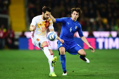Một pha tranh bóng giữa cầu thủ hai đội Tây Ban Nha (áo trắng) và Italy (áo xanh) trong trận đấu giao hữu hồi tháng Ba. (Nguồn: AFP)