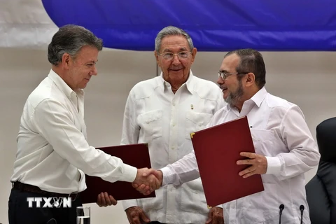 Tổng thống Colombia Juan Manuel Santos (trái), thủ lĩnh FARC Timoleon Jimenez (phải) và Chủ tịch Cuba Raul Castro tại lễ ký kết ở La Habana (Cuba), ngày 23/6. (Nguồn: EPA/TTXVN)