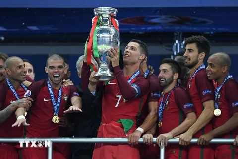 Cristiano Ronaldo (giữa) cùng các đồng đội trong niềm vui chiến thắng khi nâng cao chiếc cúp vô địch EURO 2016. (Nguồn: AFP/TTXVN)