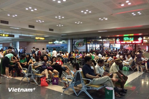 Hành khách ngồi chờ bay tại sân bay Nội Bài sáng 28/7. (Ảnh: PV/Vietnam+)
