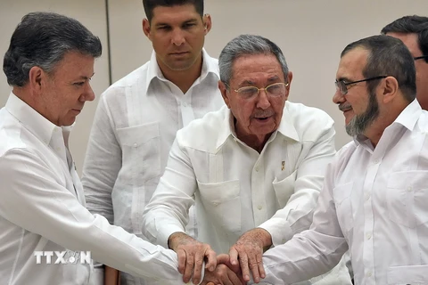 Thủ lĩnh FARC Timoleon Jimenez (phải) và Tổng thống Colombia Juan Manuel Santos (trái), Chủ tịch Cuba Raul Castro (giữa) tại lễ ký kết thỏa thuận hòa bình ở La Habana. (Nguồn: AFP/TTXVN)