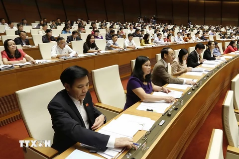 Các đại biểu Quốc hội biểu quyết thông qua Nghị quyết phê chuẩn quyết toán ngân sách nhà nước năm 2014. (Ảnh: An Đăng/TTXVN)