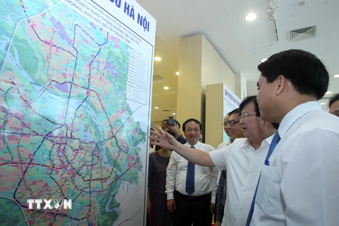 Phó Thủ tướng Trịnh Đình Dũng cùng các đại biểu xem bản đồ Quy hoạch giao thông vận tải thủ đô Hà Nội đến năm 2030 - Tầm nhìn đến năm 2050. (Ảnh: Tuấn Anh/TTXVN)