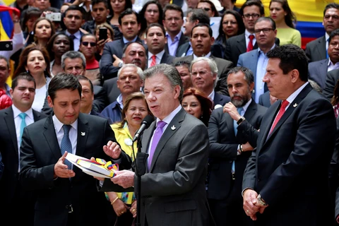 Tổng thống Colombia Juan Manuel Santos bàn giao văn kiện thỏa thuận hòa bình với FARC cho lãnh đạo quốc hội, ngày 25/8. (Nguồn: Reuters)