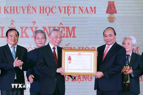 Thủ tướng Nguyễn Xuân Phúc trao tặng Huân chương Lao động Hạng Nhất lần thứ II cho Hội Khuyến học Việt Nam. (Ảnh: Thống Nhất/TTXVN)