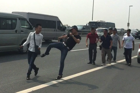 Phóng viên Quang Thế (áo trắng) bị hành hung khi đang tác nghiệp trên cầu Nhật Tân. (Nguồn: Báo Tuổi Trẻ)