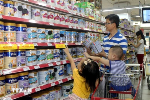 Người tiêu dùng chọn mua sản phẩm sữa giảm giá tại hệ thống bán lẻ của Saigon Co.op. (Ảnh: Thanh Vũ/TTXVN)
