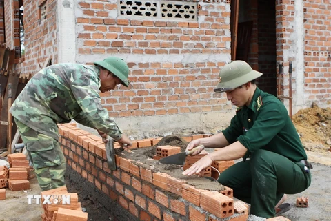 Các chiến sỹ Đồn Biên phòng Ia R’Vê, huyện Ea Súp, tỉnh Đắk Lắk góp ngày công xây dựng nhà ở cho hộ nghèo. (Ảnh: Dương Giang/TTXVN)
