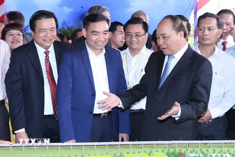Thủ tướng Nguyễn Xuân Phúc và các đại biểu tham quan các gian hàng trưng bày tại hội nghị. (Ảnh: Thống Nhất/TTXVN)