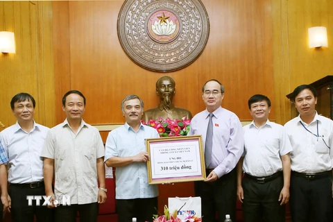 Chủ tịch Ủy ban Trung ương Mặt trận Tổ quốc Việt Nam Nguyễn Thiện Nhân tiếp nhận số tiền ủng hộ đồng bào miền Trung của TTXVN. (Ảnh: Nguyễn Dân/TTXVN)