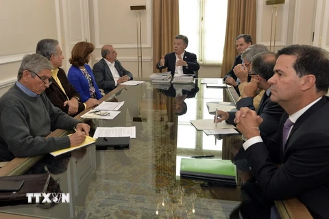 Tổng thống Juan Manuel Santos (giữa) trong cuộc gặp với Trưởng đoàn đàm phán của Chính phủ Colombia và Ủy viên cấp cao phụ trách về đàm phán hòa bình, ngày 21/10. (Nguồn: EPA/TTXVN)