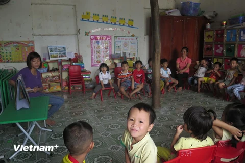 Một lớp học tạm bợ với cột gỗ chống đỡ trần nhà ở giữa. (Ảnh: Mạnh Minh/Vietnam+)