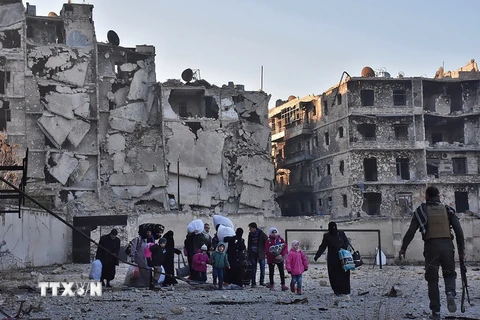 Người dân Syria sơ tán khỏi khu vực phía đông Aleppo để đến quận Bab al-Hadid - nơi quân Chính phủ giành lại quyền kiểm soát từ phiến quân, ngày 7/12. (Nguồn: AFP/TTXVN)