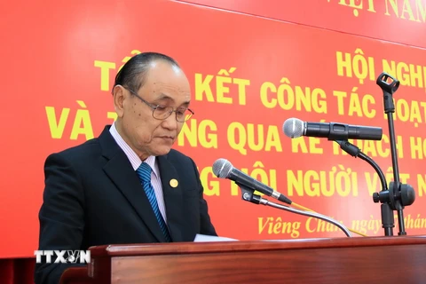 Ông Trần Văn Thọ, Chủ tịch Hội người Việt Nam tại tỉnh Khammoun, Trung Lào đọc báo cáo tại Hội nghị. (Ảnh: Phạm Kiên/TTXVN)