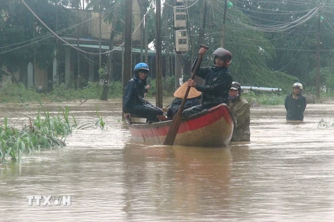Công an, bộ đội dùng canô đi cứu hộ người dân ở huyện Mộ Đức, Quảng Ngãi. (Ảnh: Phước Ngọc/TTXVN)