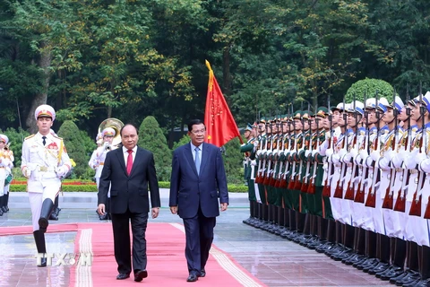 Thủ tướng Nguyễn Xuân Phúc và Thủ tướng Campuchia Hun Sen duyệt Đội Danh dự tại lễ đón chính thức sáng 20/12. (Ảnh: Thống Nhất/TTXVN)