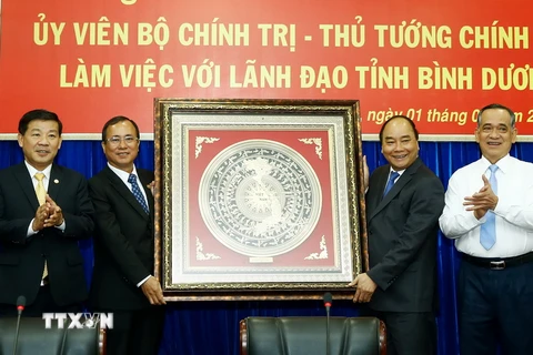 Thủ tướng Nguyễn Xuân Phúc trao tặng biểu tượng “Mặt trống đồng Ngọc Lũ” cho tỉnh Bình Dương. (Ảnh:Thống Nhất/TTXVN)