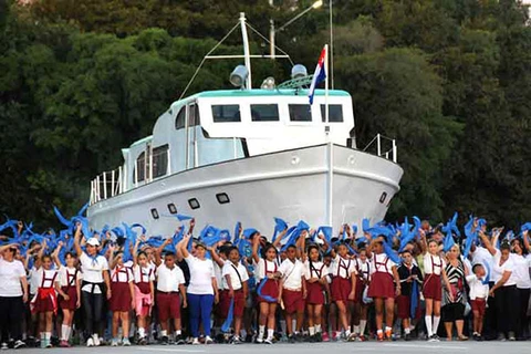 Thanh, thiếu niên Cuba diễu hành phía trước mô hình chiếc thuyền Granma. (Nguồn: Prensa Latina)