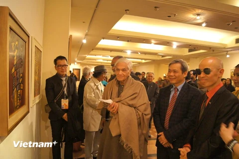 Đại sứ Tôn Sinh Thành (thứ hai từ phải qua) cùng các đại biểu tham quan triển lãm. (Ảnh: Huy Bình/Vietnam+)