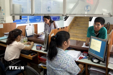 Người dân nộp thuế tại bộ phận “một cửa” của Cục thuế Thành phố Hồ Chí Minh. (Ảnh: Hoàng Hùng/TTXVN)