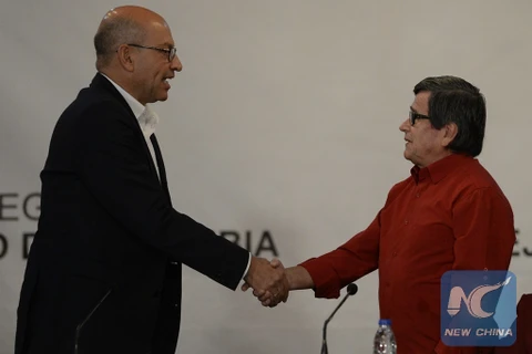 Ảnh tư liệu: Trưởng đoàn đàm phán của Chính phủ Colombia Mauricio Rodriguez (trái) bắt tay đại diện đàm phán ELN Pablo Beltran sau cuộc họp báo chung ở trụ sở Bộ Ngoại giao Venezuela tháng 10/2016. (Nguồn: Xinhua)