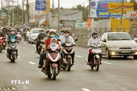 Người dân về Thành phố Hồ Chí Minh bằng xe máy tại nút giao thông Bình Chánh sau kỳ nghỉ Tết Nguyên đán. (Ảnh: Tuấn Anh/TTXVN phát)