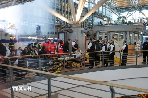 Hành khách được sơ tán ra bên ngoài tòa nhà sân bay ở Hamburg, sau khi phát hiện mùi lạ bất thường trong không khí. (Nguồn: AFP/TTXVN)