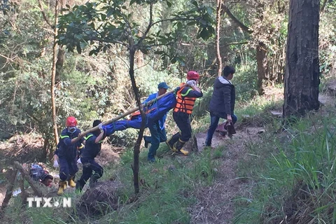 Lực lượng cứu hộ đưa thi thể hai nạn nhân xấu số lên khỏi thác Hang Cọp. (Ảnh: Nguyễn Dũng/TTXVN)