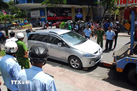 Xử lý ôtô đỗ lấn chiếm vỉa hè, lề đường ở quận 1, Thành phố Hồ Chí Minh. (Ảnh: Mạnh Linh/TTXVN)