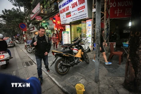 Đậu xe máy ngang nhiên chắn ngang lối đi trên vỉa hè dành cho người đi bộ trên phố Hàng Bông. (Ảnh: Trọng Đạt/TTXVN)