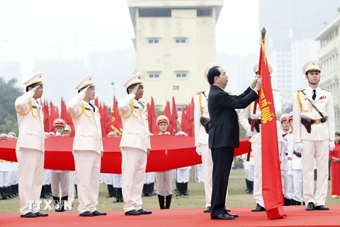 Chủ tịch nước Trần Đại Quang gắn Huân chương Chiến công hạng Nhất lên cờ truyền thống của đơn vị. (Ảnh: Nhan Sáng/TTXVN)