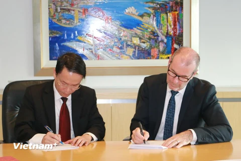 Ủy viên Trung ương Đảng, Tổng Giám đốc TTXVN Nguyễn Đức Lợi ký thỏa thuận hợp tác với Chủ tịch AAP Bruce Davidson. (Ảnh: Sơn Hà/Vietnam+)