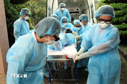 Cán bộ y tế chuyển bệnh nhân nghi mắc cúm A (H7N9) tới khu điều trị cách ly. (Ảnh: Thái Thuần/TTXVN)