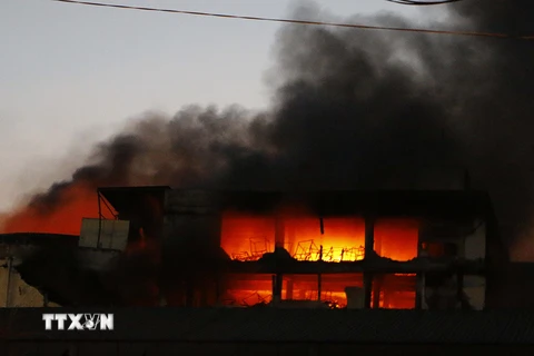 Lửa vẫn cháy dữ dội tại khu vực phía sau tòa nhà công ty Kwong Lung-Meko, ngày 23/3. (Ảnh: Thanh Liêm/TTXVN)