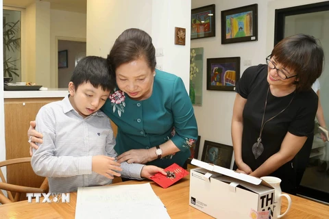 Phu nhân Chủ tịch nước Trần Đại Quang, bà Nguyễn Thị Hiền tặng quà cho bé ​Nem. (Ảnh: Doãn Tấn/TTXVN)
